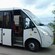 A man climbing into the drivers seat of an empty bus